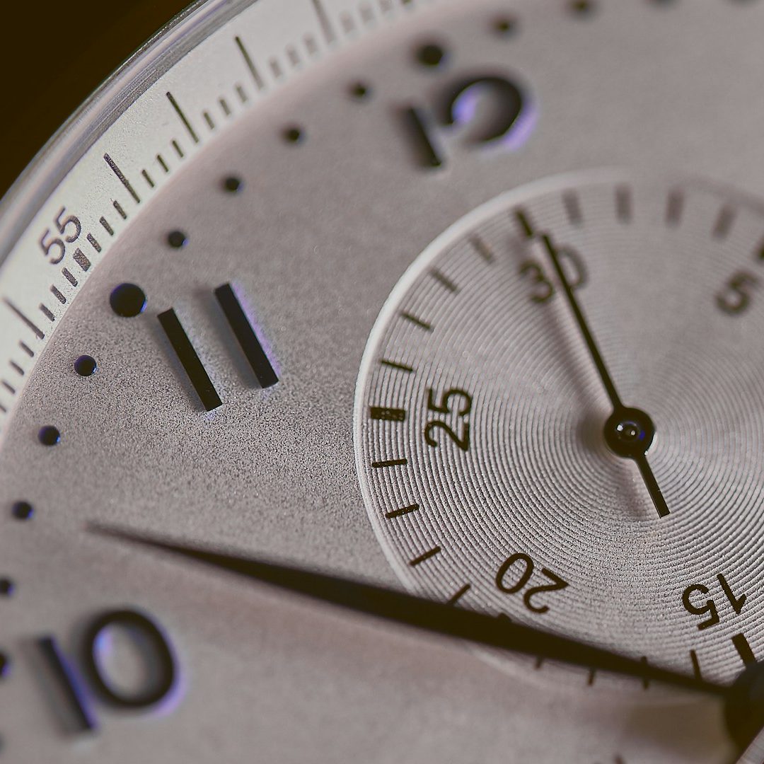 Horloge Gros plan sur un cadran de montre avec des aiguilles et des chiffres en relief.